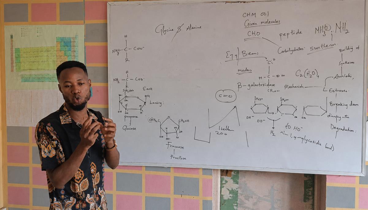 A tutor explaining syllabus topics at a whiteboard